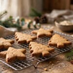 Homemade gingerbread-style dog biscuits shaped like stars and Christmas trees cooling on a wire rack