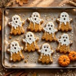 Homemade Halloween dog treats — pumpkin ghost biscuits decorated with yoghurt on a baking tray